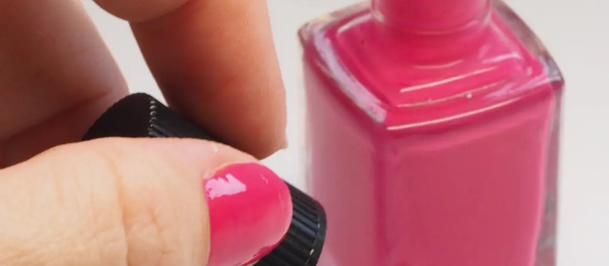 Uñas pintándose con esmalte rosa